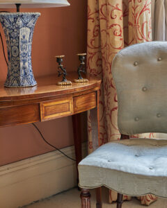 chair and side table with lamp and candlesticks