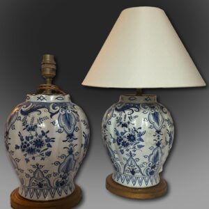 Pair of 18th century Dutch Delft lamps , signed Duijn. Baluster shaped and decorated in two shades of blue on a white background , newly converted to lamps ,they stand on a round base and are decorated all round with four panels of charming flowers which in turn are divided by four panels of stylised leaves .