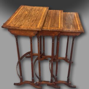 A fine George III Nest of three Tables in Kingwood with Satinwood crossbanding, on elegant turned legs supported by bow stretchers and standing on scrolled feet of unusual design.