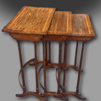 A fine George III Nest of three Tables in Kingwood with Satinwood crossbanding, on elegant turned legs supported by bow stretchers and standing on scrolled feet of unusual design.